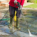person pressure washing patio house 1359541598