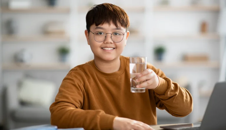 positive asian teenager holding glass of water whi 2021 12 09 19 23 31 utc1