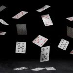playing cards fall on a black table.jpg