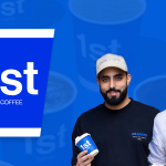 Two men holding 1st Coffee cups.