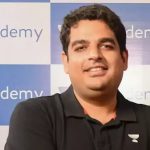 Person in front of Unacademy banner